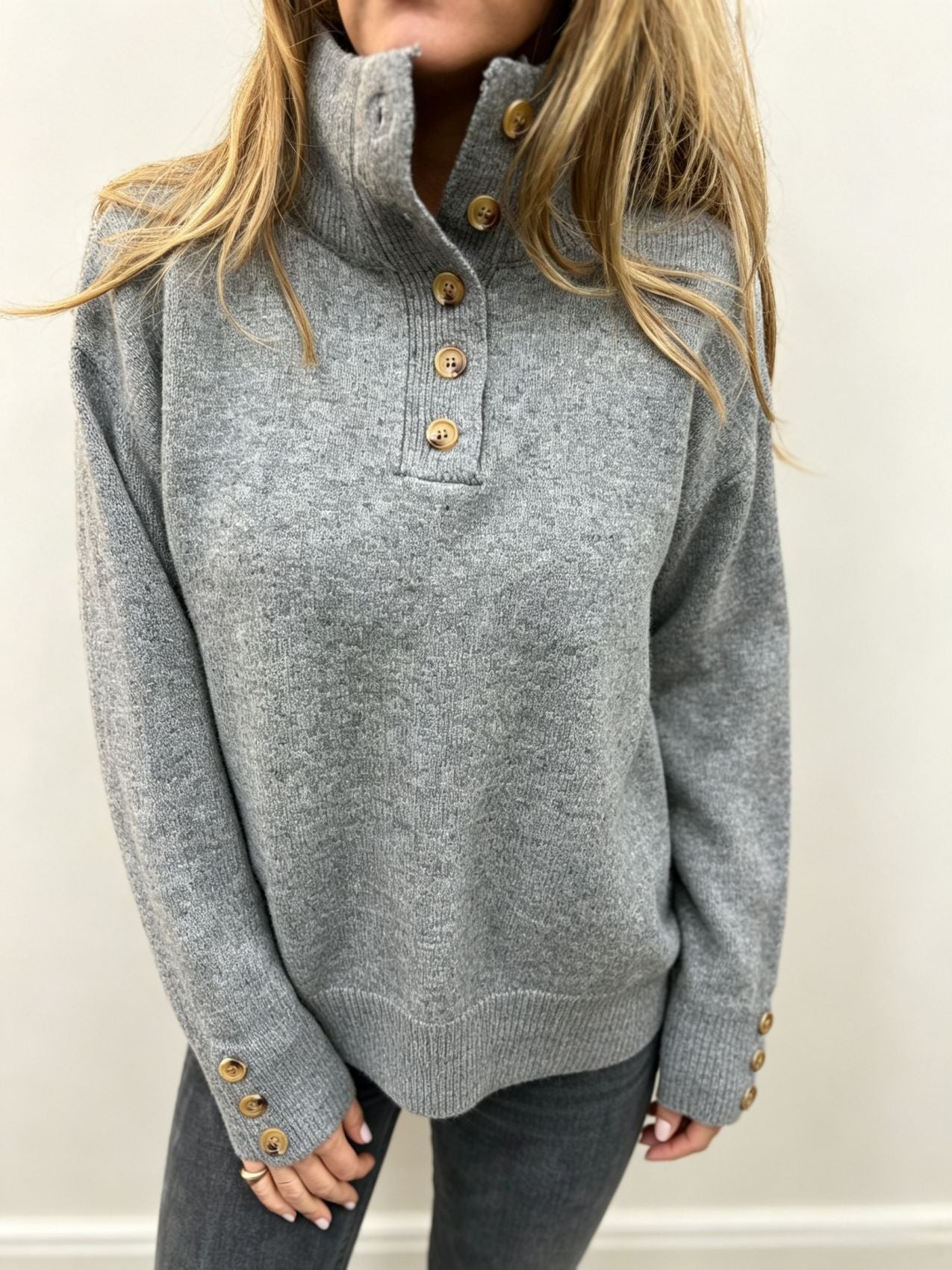 Grey knit long-sleeve pullover with buttoned neckline and ribbed hem, gold-tone buttons