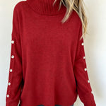 Oversized red long-sleeve turtleneck sweater with buttoned sleeve cuffs