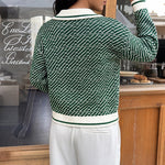 Green V-neck sweater back view with knit pattern and white ribbed waistband and cuffs.