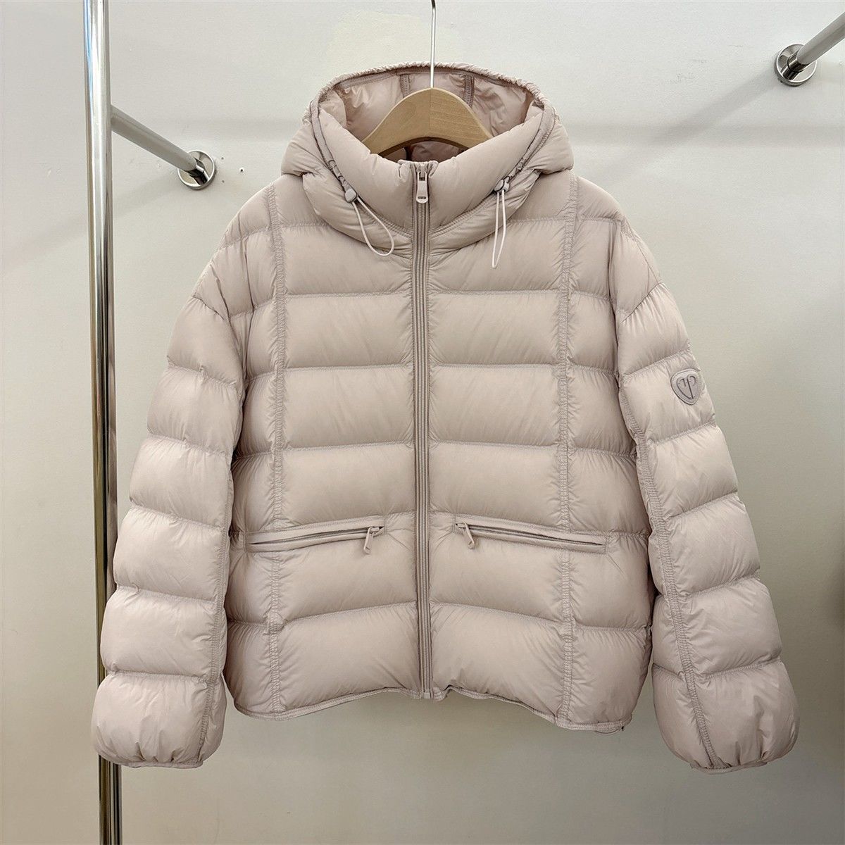 Short padded hooded thermal jacket in light pink with full-zip front and side zip pockets