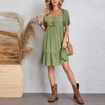 Green V-neck tiered midi dress with short sleeves, worn with ankle boots