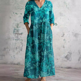 Floral long dress in teal with V-neck and three-quarter sleeves, gathered waist