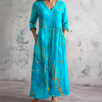 Floral long dress in bright teal with V-neck and three-quarter sleeves, gathered waist