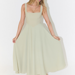 Sage green square-neck sleeveless midi dress, full skirt with gentle flare and pockets