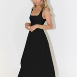 Black square-neck sleeveless midi dress with full skirt and subtle pleats at the waist