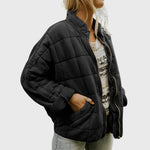 Black quilted comfort jacket, full-zip with stand collar, long sleeves, side pockets
