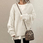 White cable-knit oversized sweater with V-neck, long sleeves, ribbed cuffs and hem