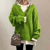 Green cable-knit oversized sweater with V-neck, long sleeves, ribbed cuffs and hem