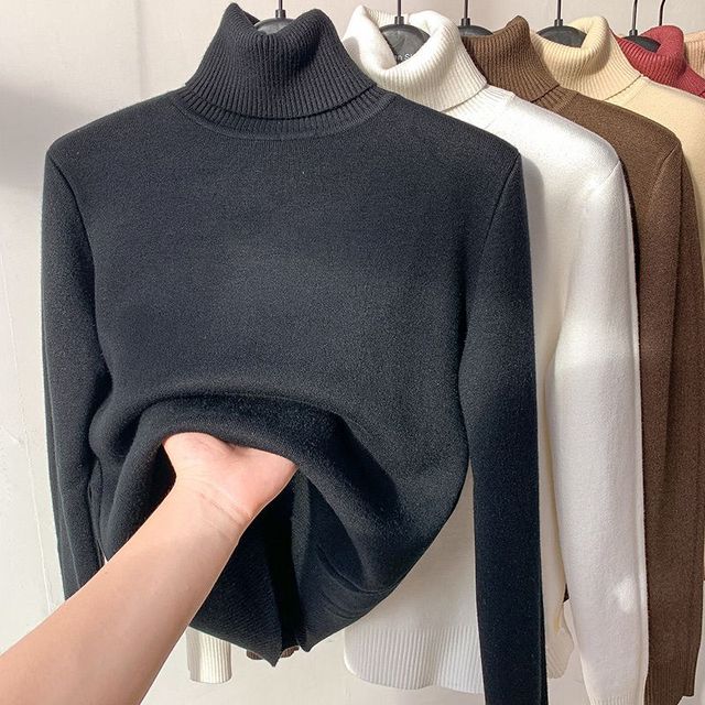 Black fleece-lined turtleneck sweater with ribbed collar and cuffs