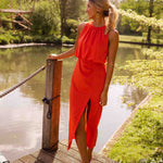 Sleeveless orange midi dress with gathered neckline and side slit, flowing drape