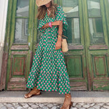 Bohemian maxi dress in green with pink floral print, flowing tiered skirt