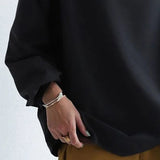 Black high-neck soft knit top with cuffed sleeves and roomy hem