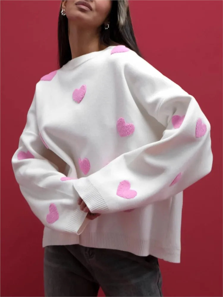 White soft pullover sweater with pink heart pattern and ribbed cuffs, crew neck.