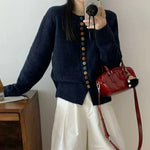 Navy knit cardigan with long sleeves and multicolor button front, ribbed cuffs and hem