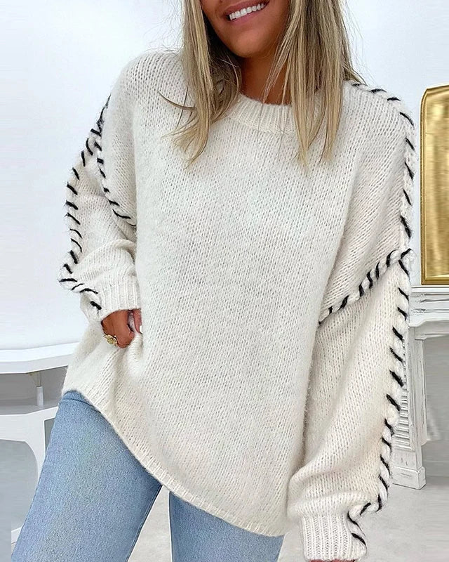 Cream chunky knit pullover with textured sleeves and visible side contrast stitching