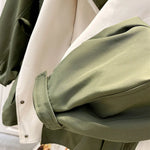 Close-up of olive-green jacket sleeve cuff with cream inner panel