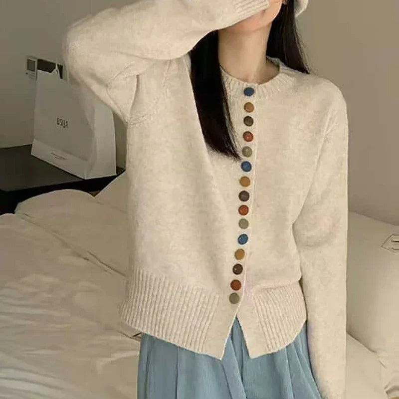 Cream knit cardigan with long sleeves and front button placket with multicolor buttons