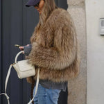 Cropped brown faux-fur jacket close-up, thick shaggy texture and long sleeves