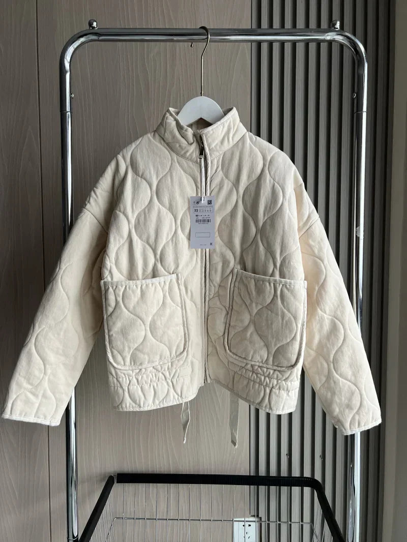 Light cream cropped quilted jacket with full zip, flap pockets, and drawstring hem