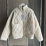 Light cream cropped quilted jacket with full zip, flap pockets, and drawstring hem