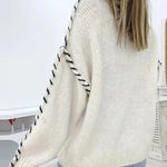 Cream knit pullover with crew neck and contrast stitched raglan-style sleeves