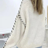 Cream knit pullover with crew neck and contrast stitched raglan-style sleeves