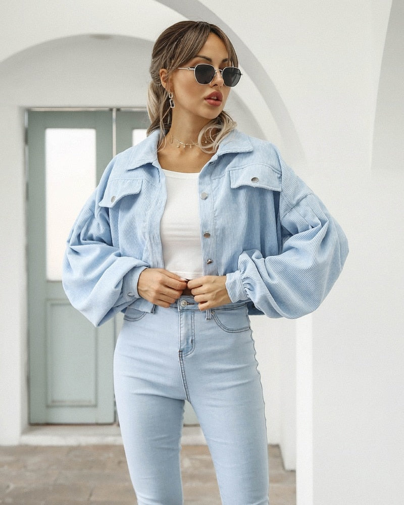 Light blue cropped jacket with flap pockets and button front, long puff sleeves