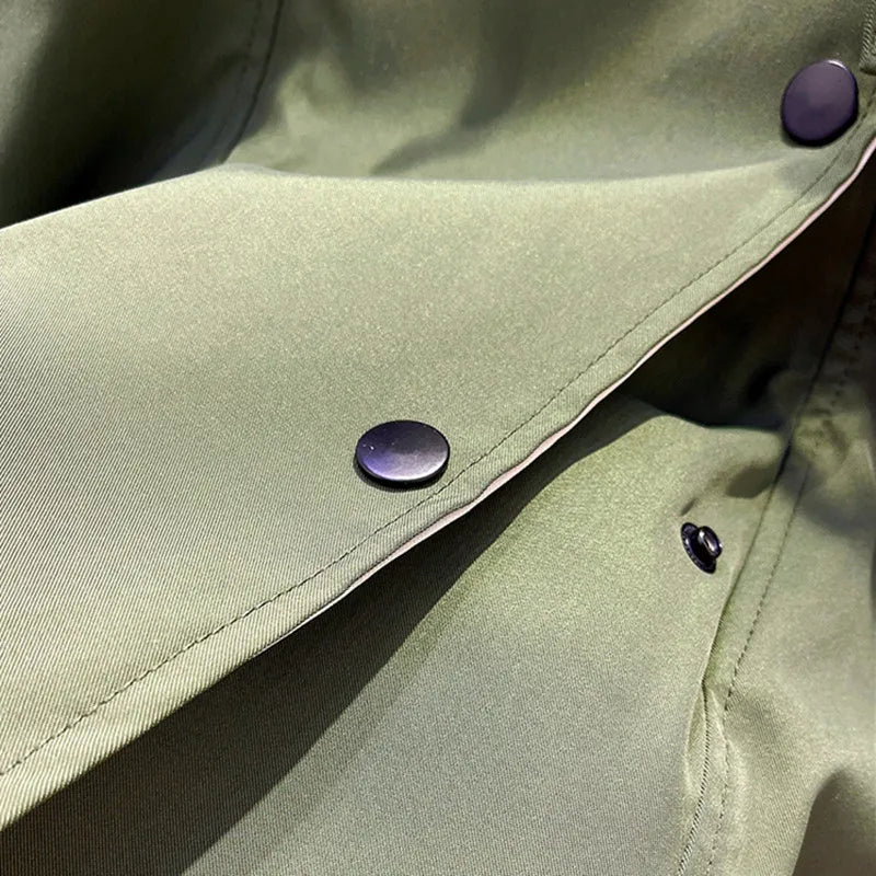 Close-up of olive-green jacket with metal snap buttons along trim