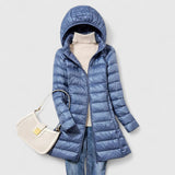 Long hooded puffer jacket with front zipper, light blue colorway.