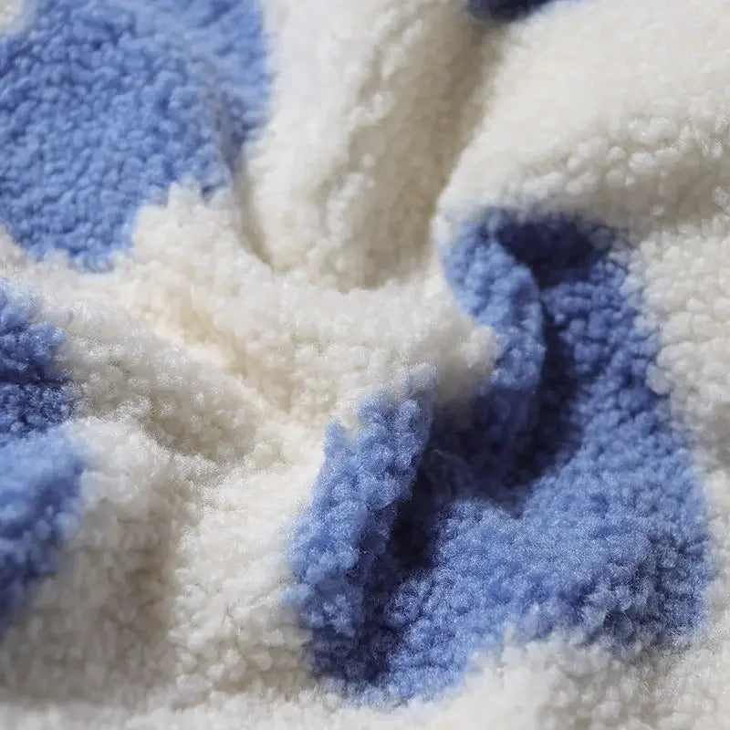 Blue heart-print sherpa fleece texture close-up with soft pile