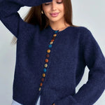 Navy knit cardigan with long sleeves and vertical row of multicolor round buttons