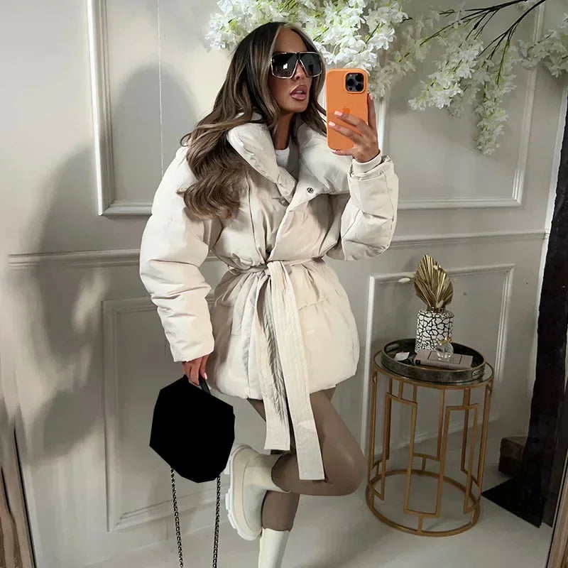 Cream padded hooded jacket with tie belt, button front and long sleeves.