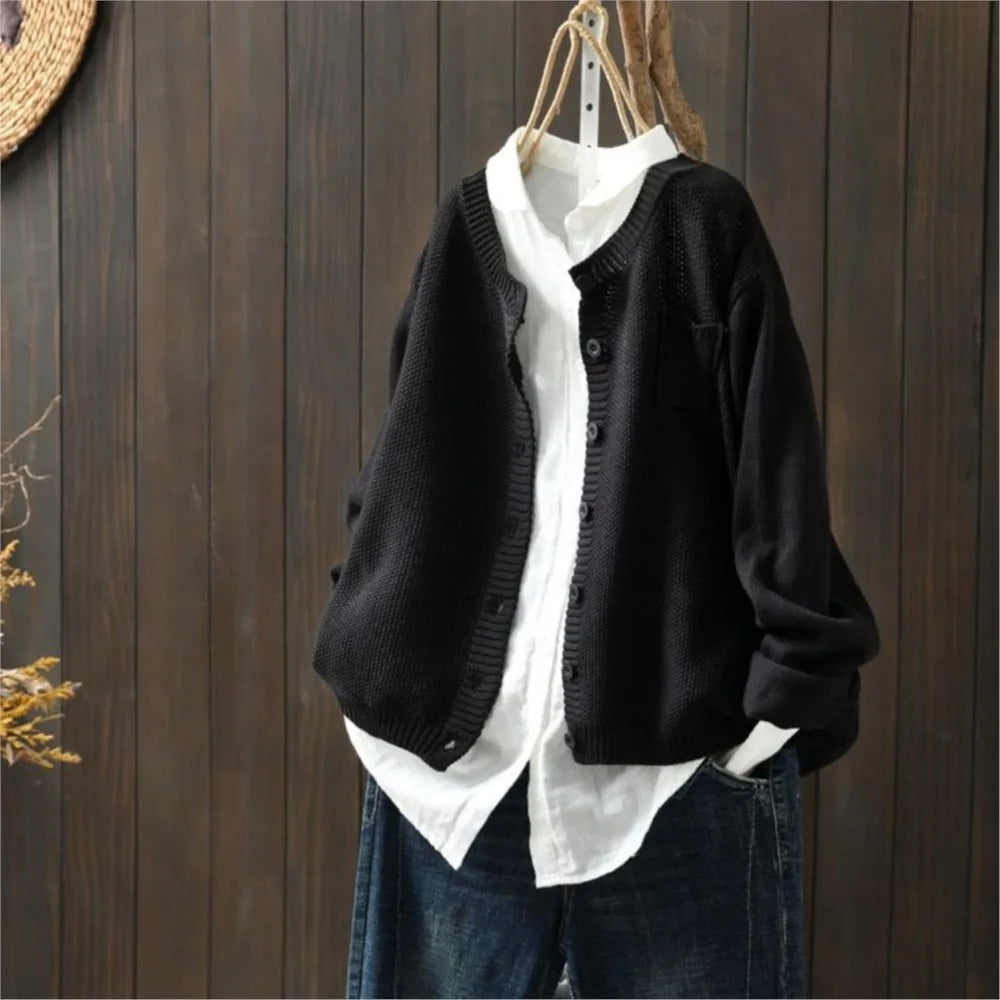 Black knit cardigan with button front, patch pockets, ribbed cuffs and hem.