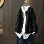 Black knit cardigan with button front, patch pockets, ribbed cuffs and hem.