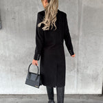 Black double-breasted overcoat from back view with long sleeves and buttoned cuffs