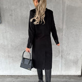 Black double-breasted overcoat from back view with long sleeves and buttoned cuffs