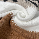 Knit close-up of colorblock pullover: white and brown with contrast zigzag trim