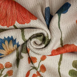 Cream knit cardigan fabric close-up with zipper seam and orange-blue floral pattern