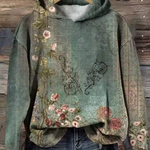 Warm green hoodie with floral front print and attached hood.