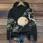 Mabel comfort hoodie, black with white floral branches and large beige full-moon graphic