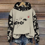 Mabel comfort hoodie, cream with black floral sleeves and small red logo patch