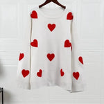 White knit pullover sweater with scattered red heart motifs, crew neck and ribbed cuffs.