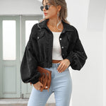Black cropped jacket with flap pockets, button front, and long puff sleeves