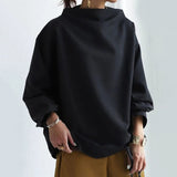 Black high-neck soft knit top with balloon sleeves and loose drape