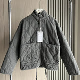 Dark gray cropped quilted jacket with full zip, flap pockets, and drawstring hem