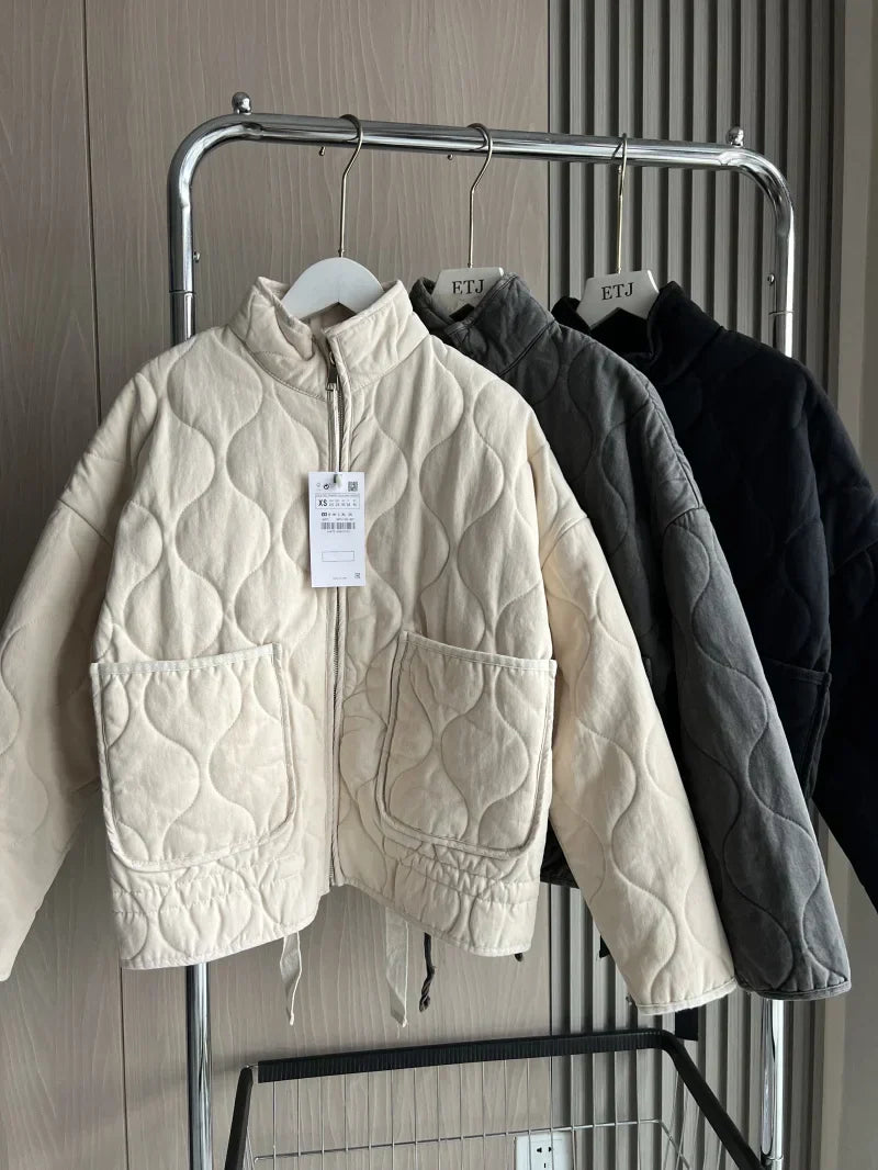 Cream cropped quilted jacket with full zip, flap pockets, and drawstring hem