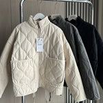 Cream cropped quilted jacket with full zip, flap pockets, and drawstring hem