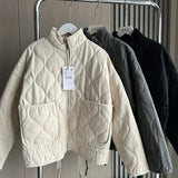 Cream cropped quilted jacket with full zip, flap pockets, and drawstring hem