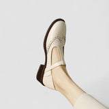 Cream orthopedic Mary Jane shoe with side buckle strap and wingtip detailing