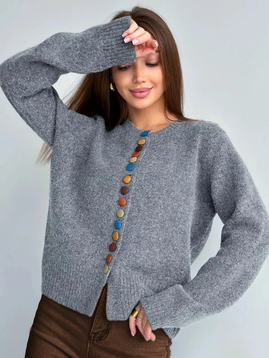 Gray knit cardigan with vertical row of multicolor round buttons and long sleeves